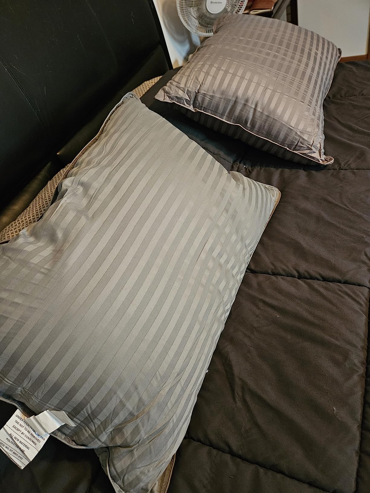 A bed with two Utopia Bed Pillows resting on it, showcasing comfort and style for a product review.