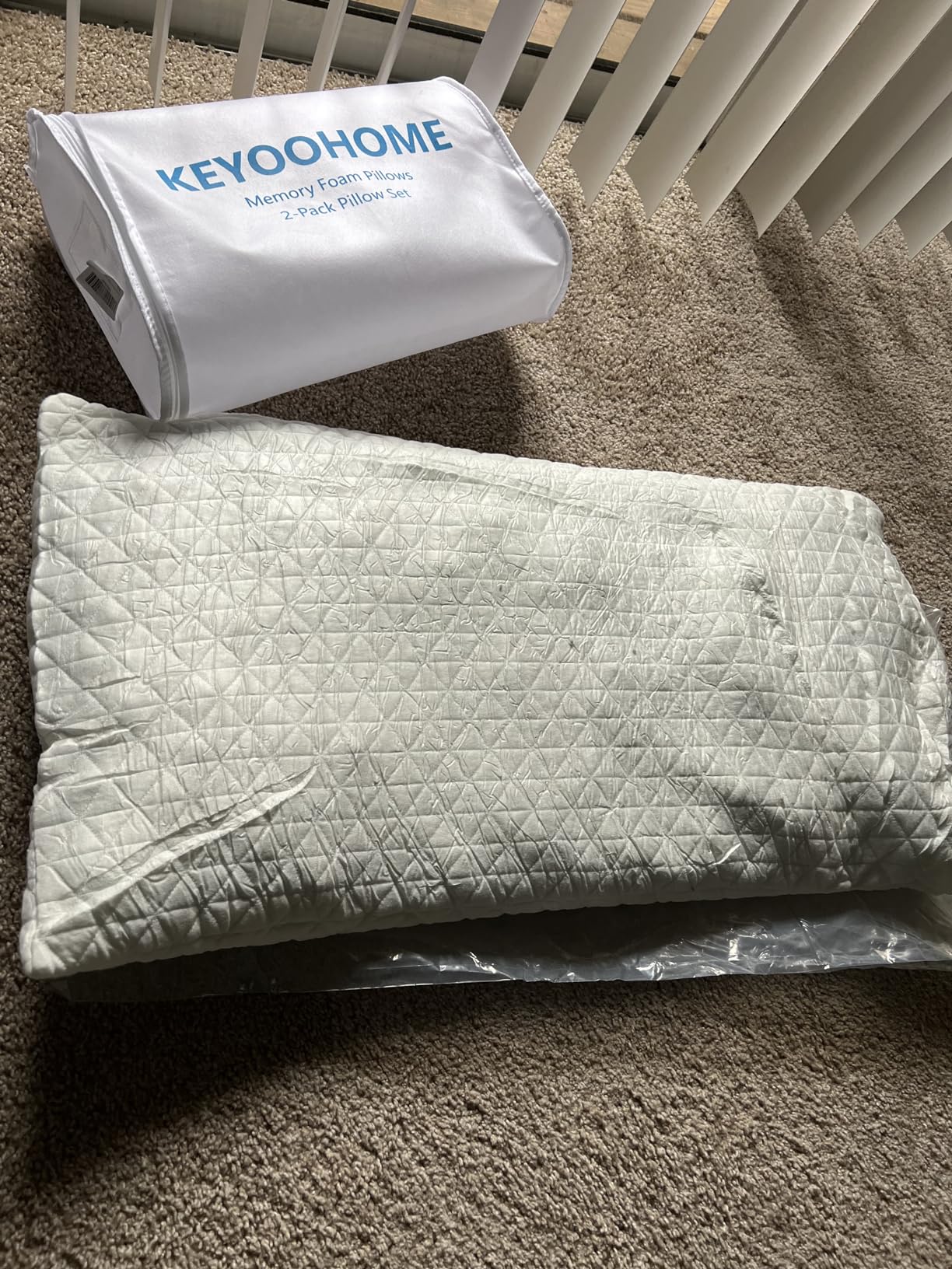 A mattress and a pillow on the floor beside a bag, showcasing Shredded Memory Foam Pillows in use condition for a product review.