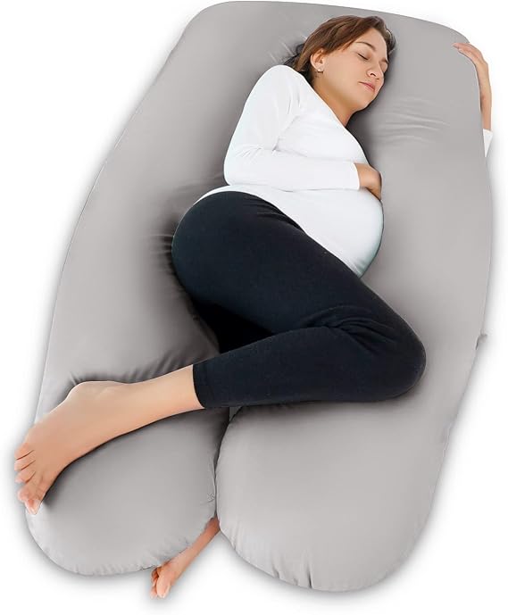 A pregnant woman resting comfortably on a large pillow, using the Meiz Pregnancy Pillow for support and relaxation.