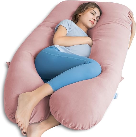 A woman resting her head on a pink pillow, using the QUEEN ROSE Pregnancy Pillow for comfort and support.