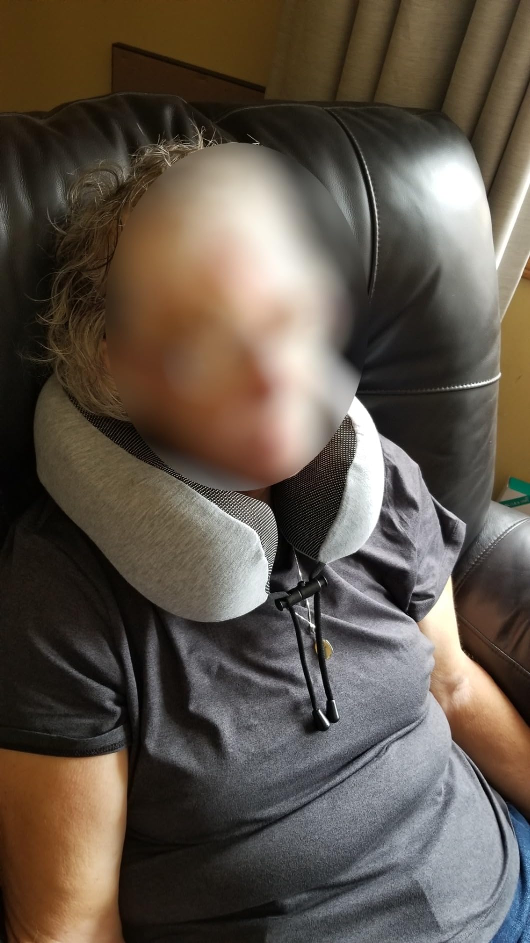 A woman sitting in a chair with a Napfun Neck Pillow for Travelling, enjoying comfort and support while relaxing.